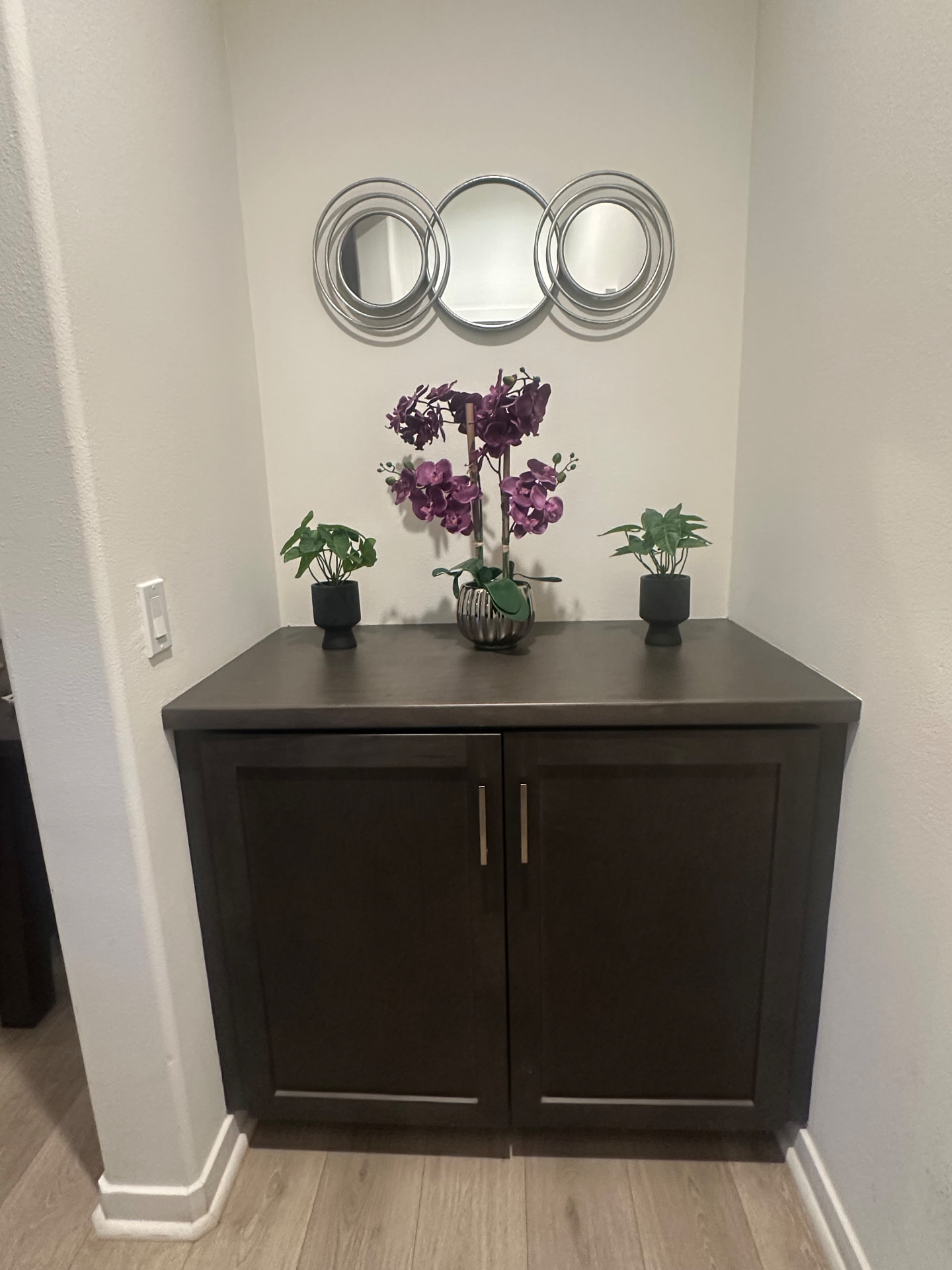Decorative entry nook with orchids and round mirrors