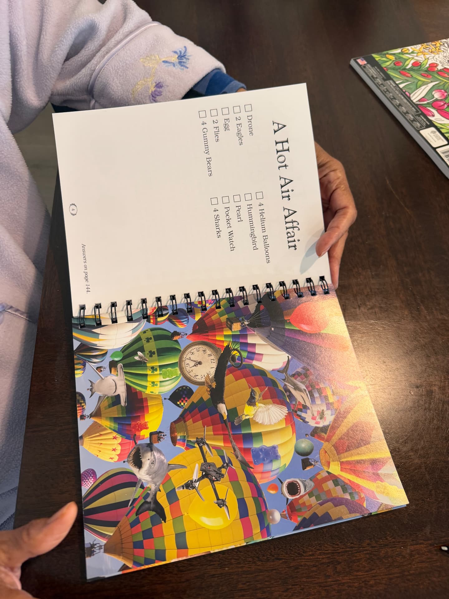 A resident working on a picture search puzzle book titled A Hot Air Affair